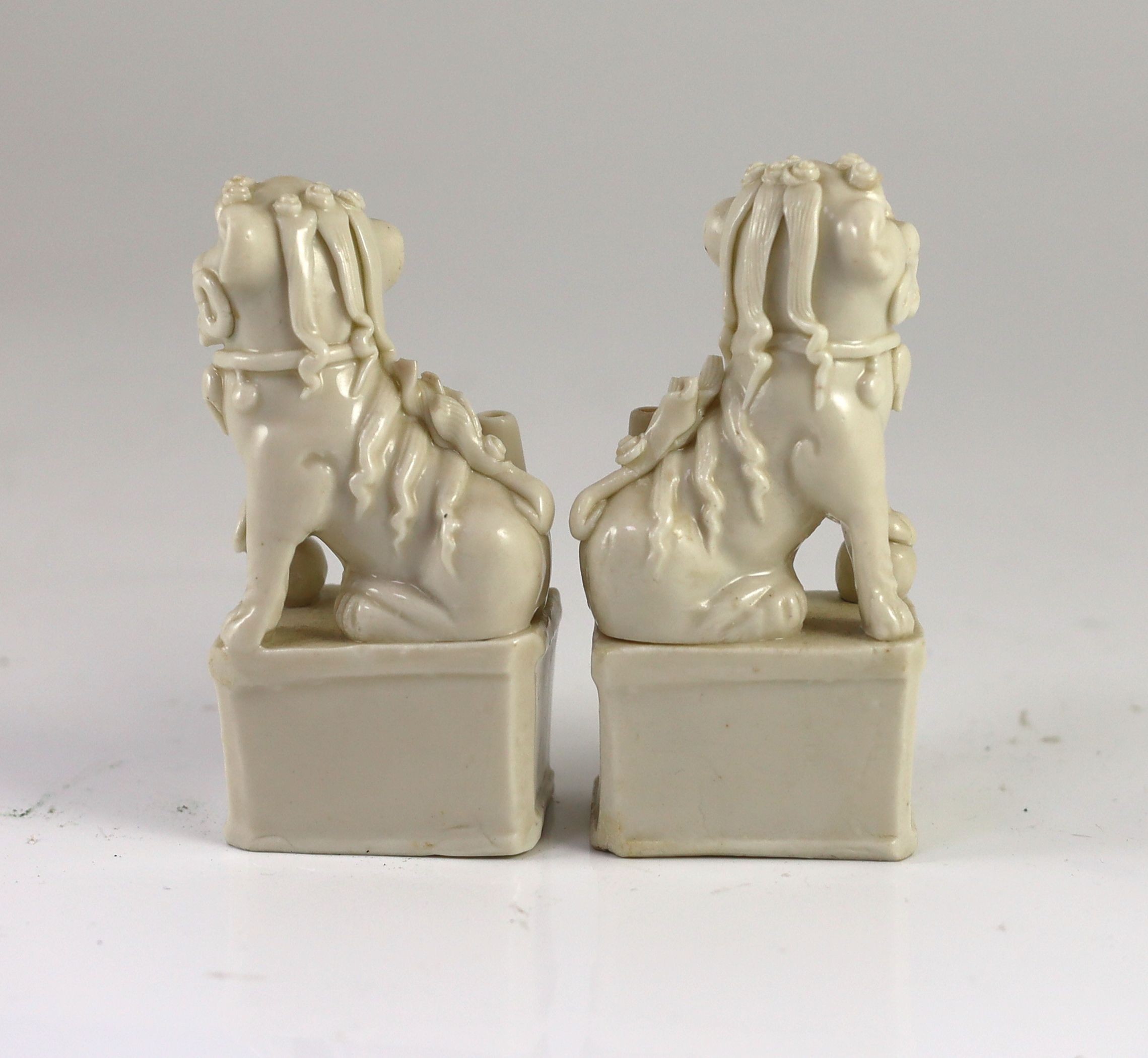 A pair of Chinese blanc-de-chine Buddhist lion joss stick holders, Dehua kilns, Kangxi period, 12.5 cm high, both damaged